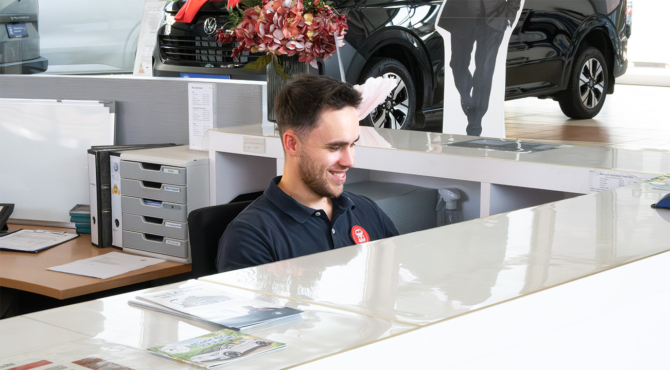 Ein Serviceassistent von Gessner & Jacobi blickt souverän und sympathisch auf seinen Monitor.