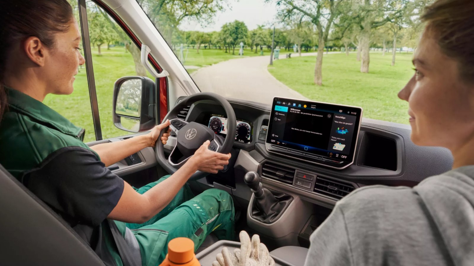 Fahrerin und Beifahrerin im Cockpit eines VW Crafter mit Schaltgetriebe