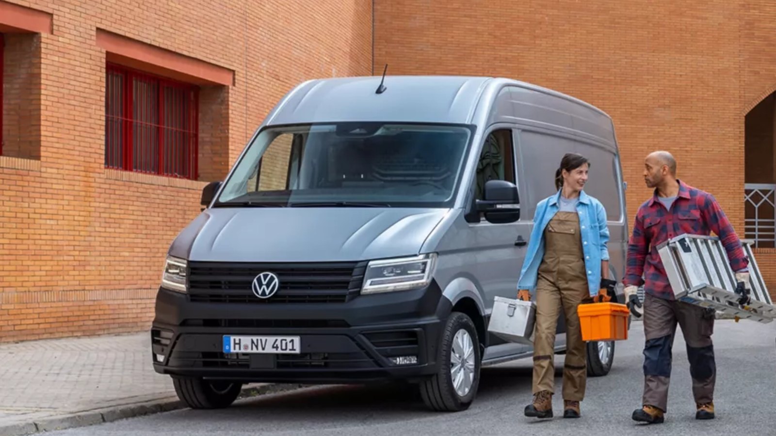 Zwei Handwerker mit Werkzeug neben einem VW Crafter Kastenwagen